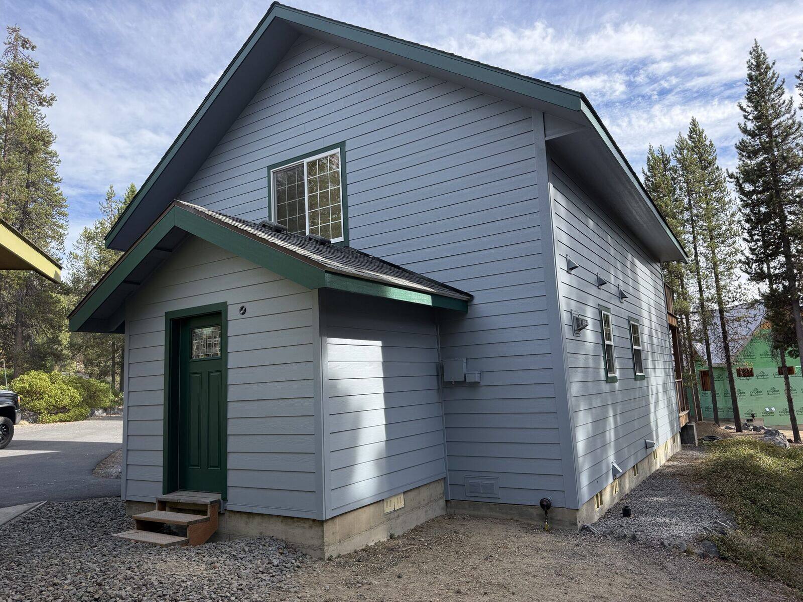 Finished HardiePlank lap siding with green trim on a two-story Crescent Lake home