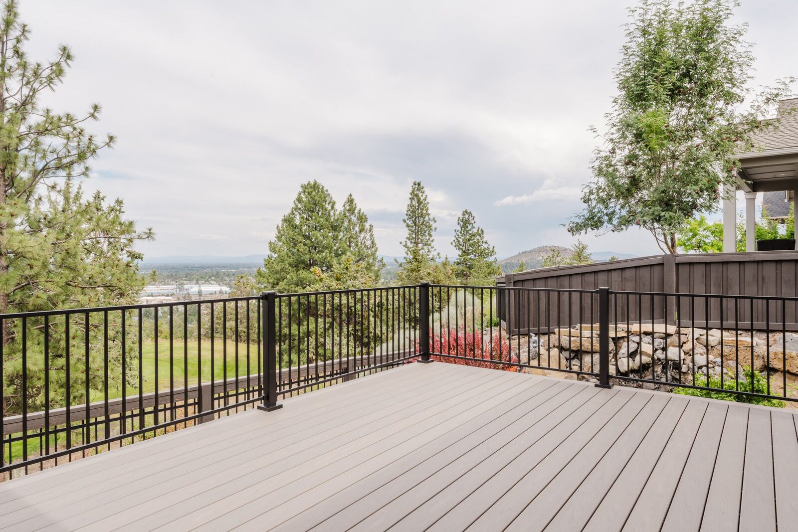 Black steel railing on a composite deck overlooking Bend